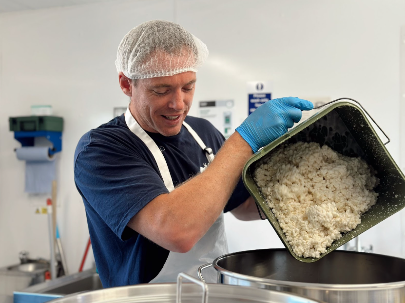 Iestyn, our Head of the Diary Department, carefully adding a batch of kefir grains to fresh goat's milk while wearing his Chuckling Goat uniform and health and safety protective gear (including hat, apron and gloves).